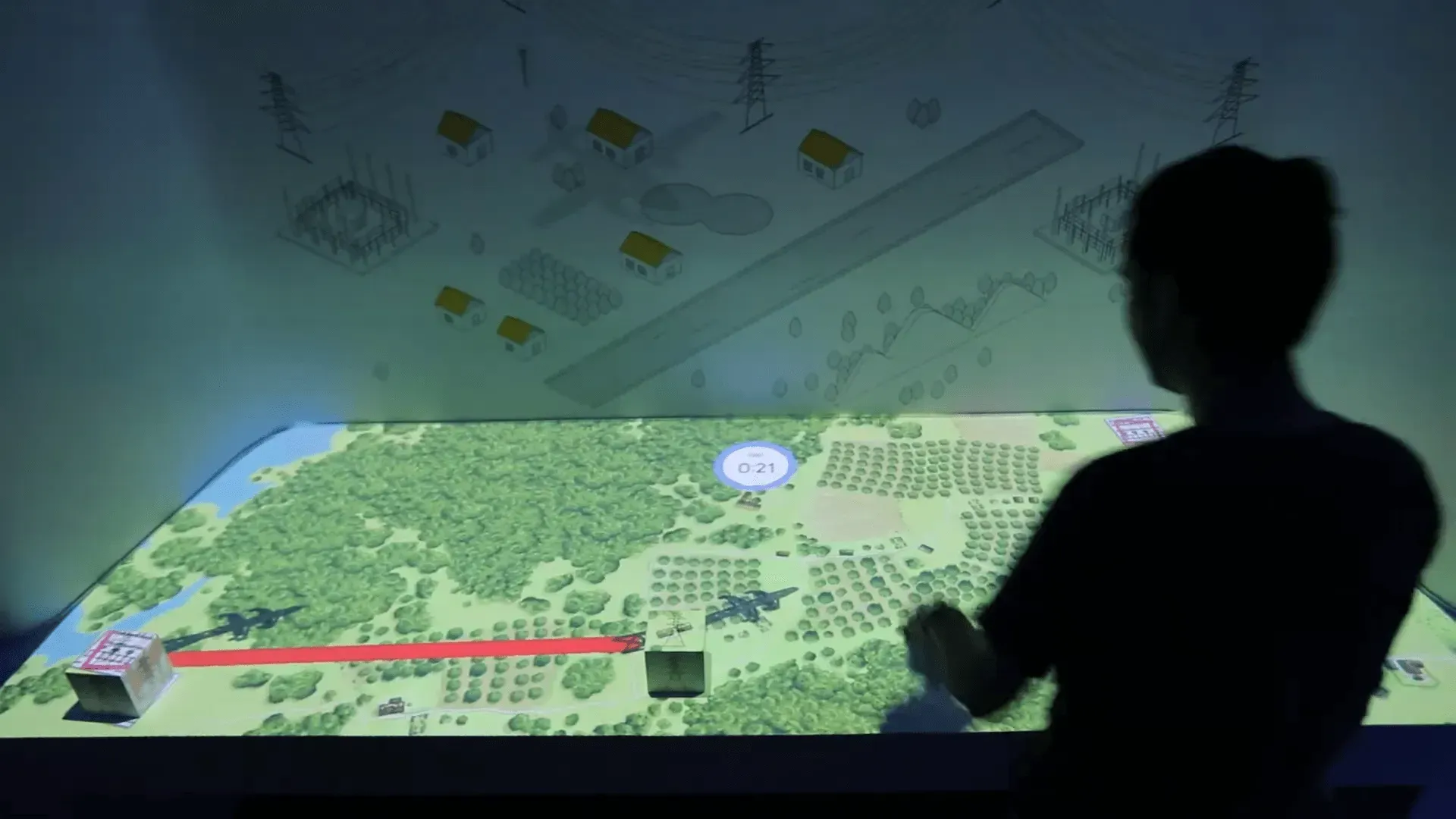 Silhouette of a person gesturing toward a large interactive landscape display with a red line and map markers