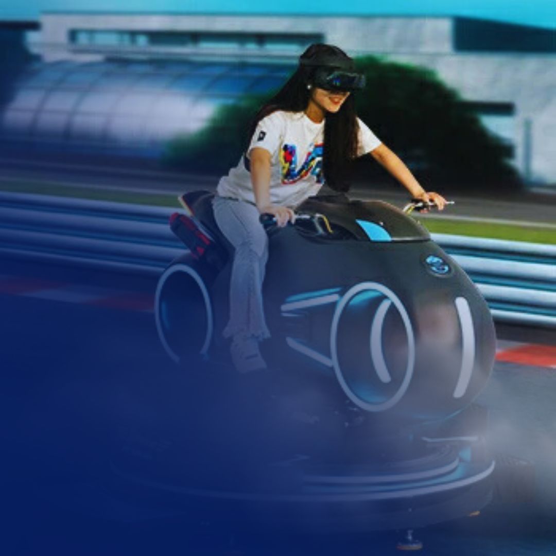 A person wears a VR headset while riding a futuristic motorcycle simulator on a virtual racetrack.