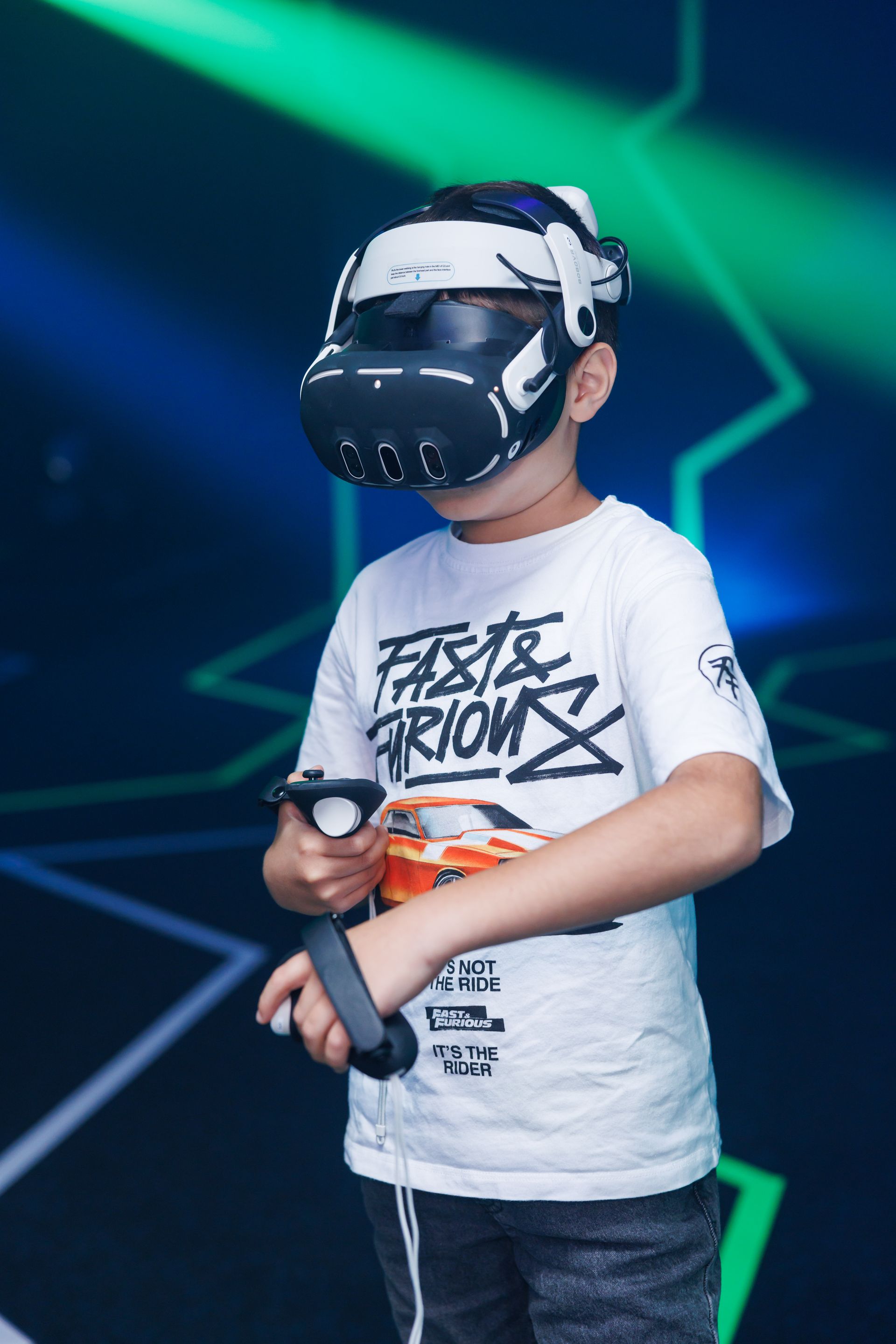 A person wearing a VR headset and holding controllers in front of a blue and green digital background.