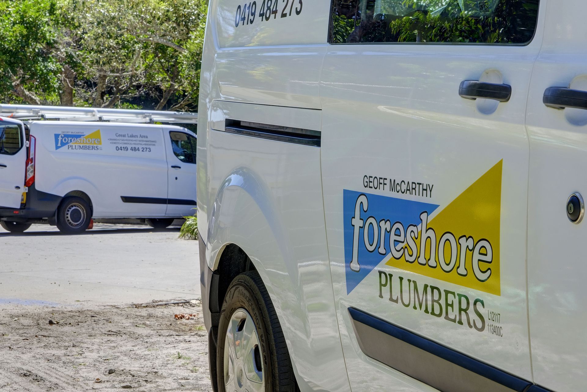 Two Foreshore Plumbers Vans Are Parked on the Side of the Road — Foreshore Plumbers In Smiths Lake, NSW
