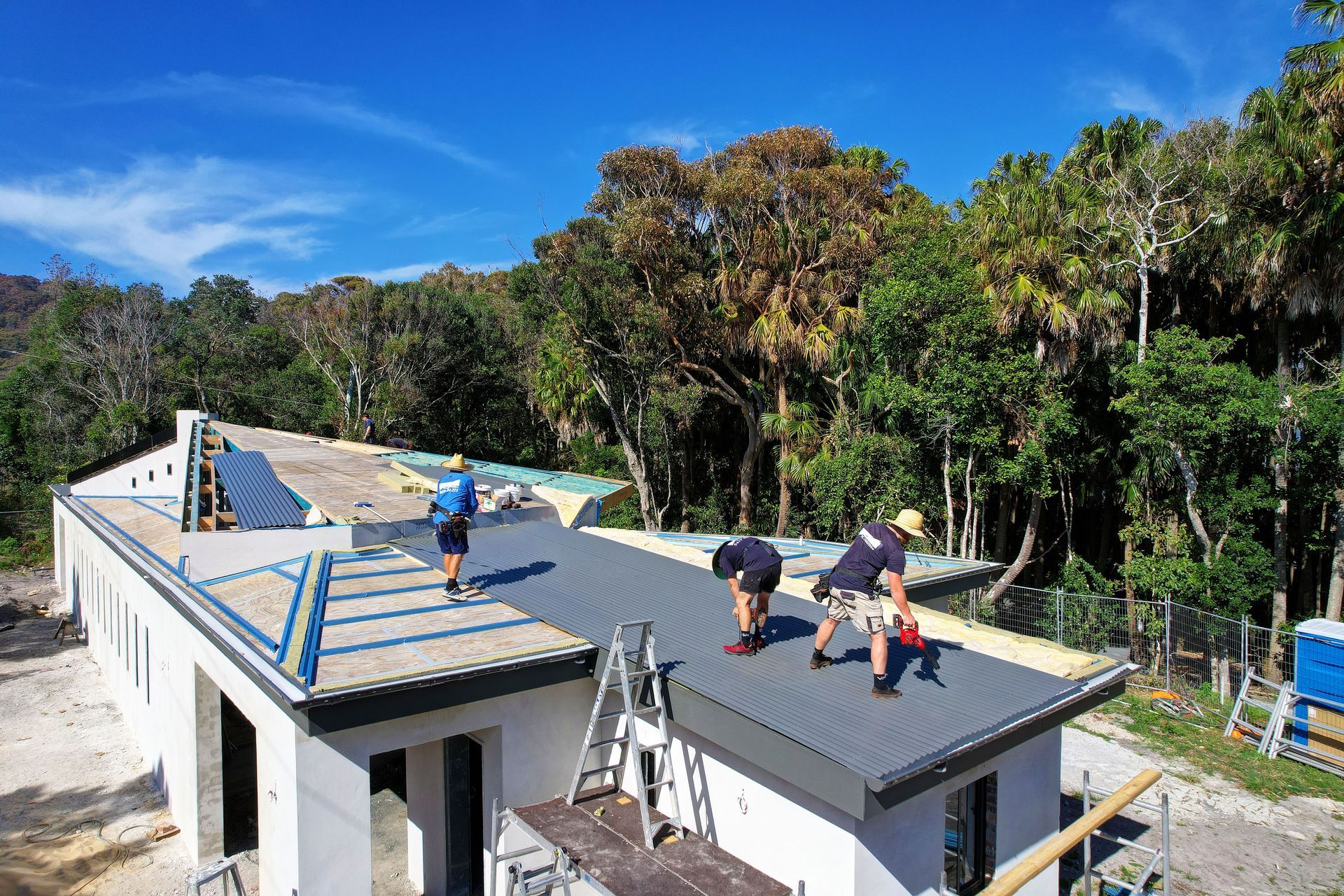 A Group of Men Are Working on the Roof of a House — Foreshore Plumbers In Forster, NSW