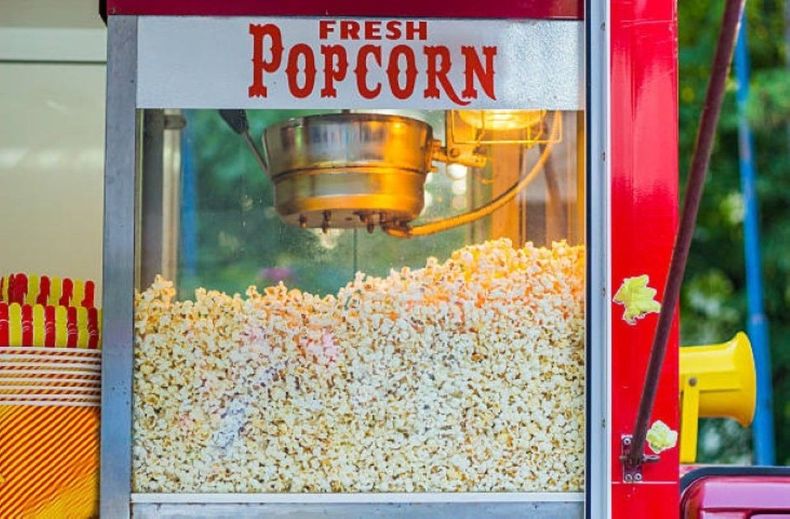 Fresh popcorn popping in a red-and-silver concession cart window
