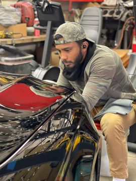 a man is working on a car in a garage .