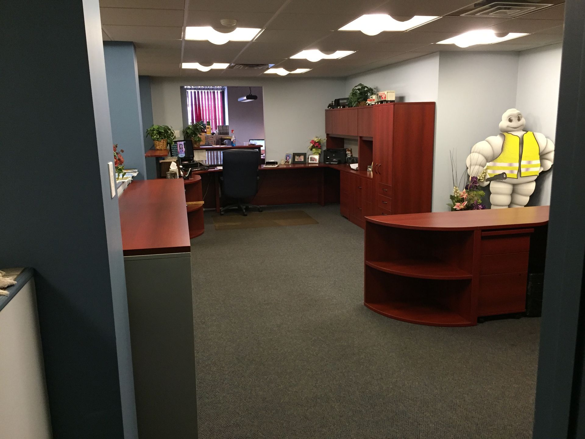 Office lobby with desks, a round table, and a mannequin in a yellow safety vest