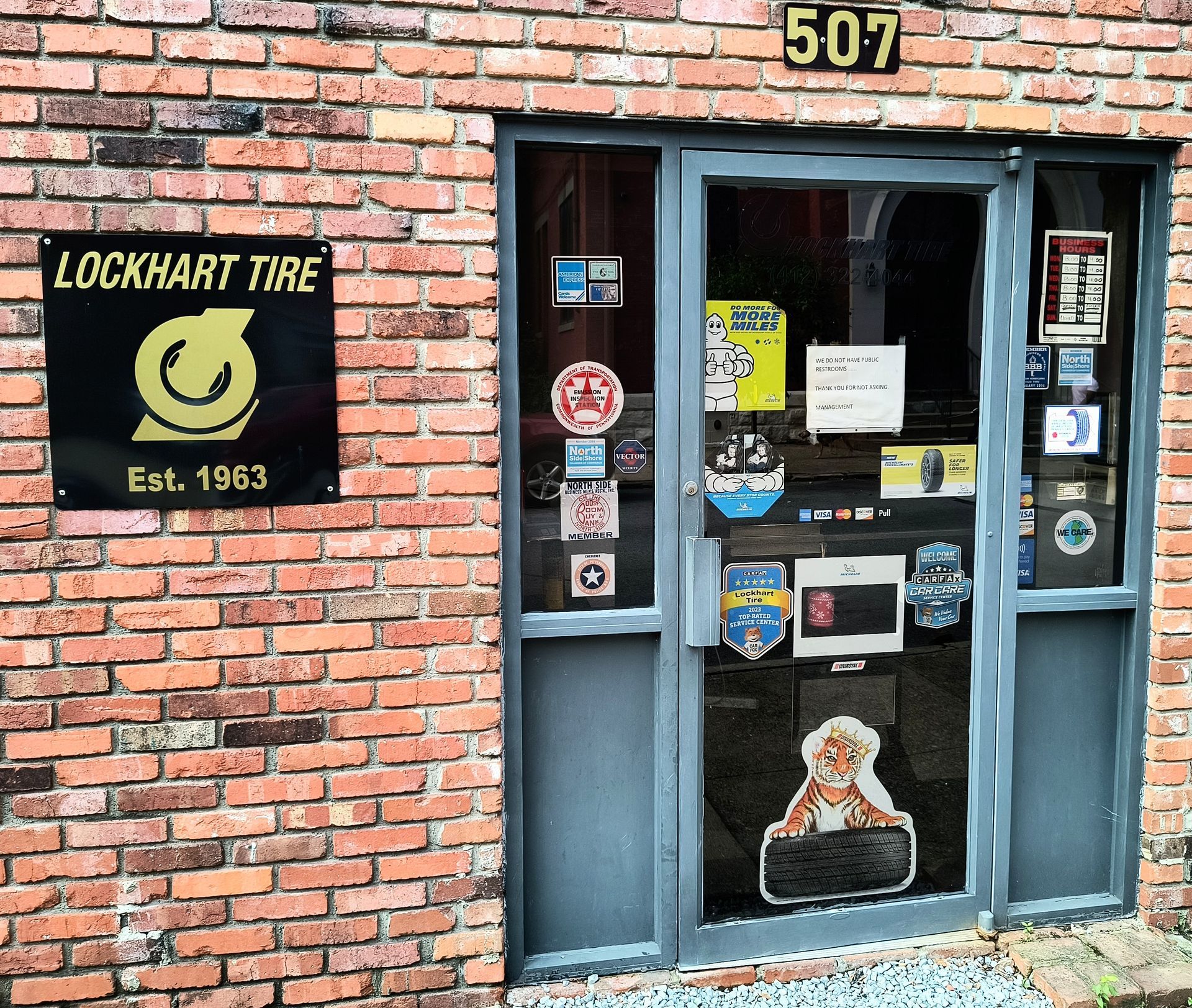 Lockhart Tire storefront with brick facade, blue door, and dog cutout at entrance