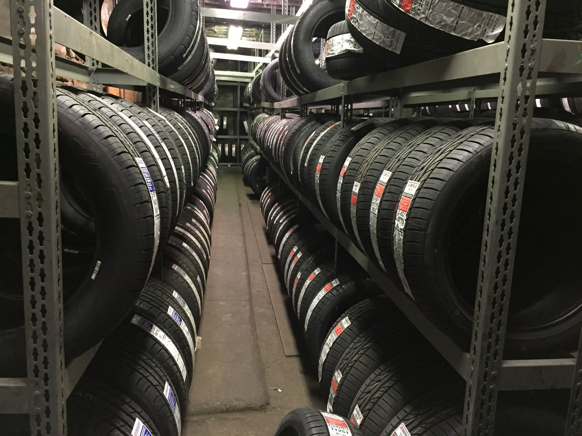 Aisle in a tire shop with rows of stacked black tires on both sides