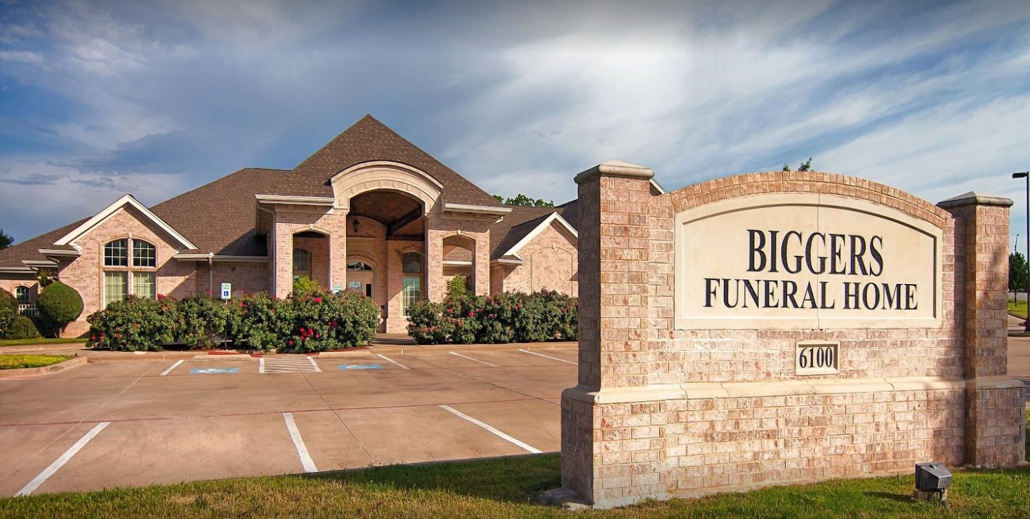 Biggers Funeral Home sign in front of a brick building and parking lot
