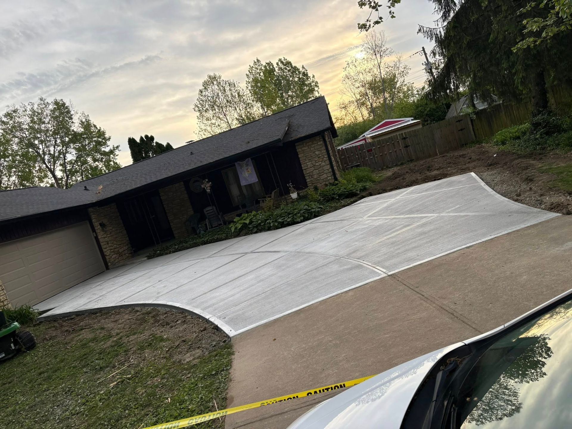 Concrete driveway with fresh white sealant in front of a house at dusk