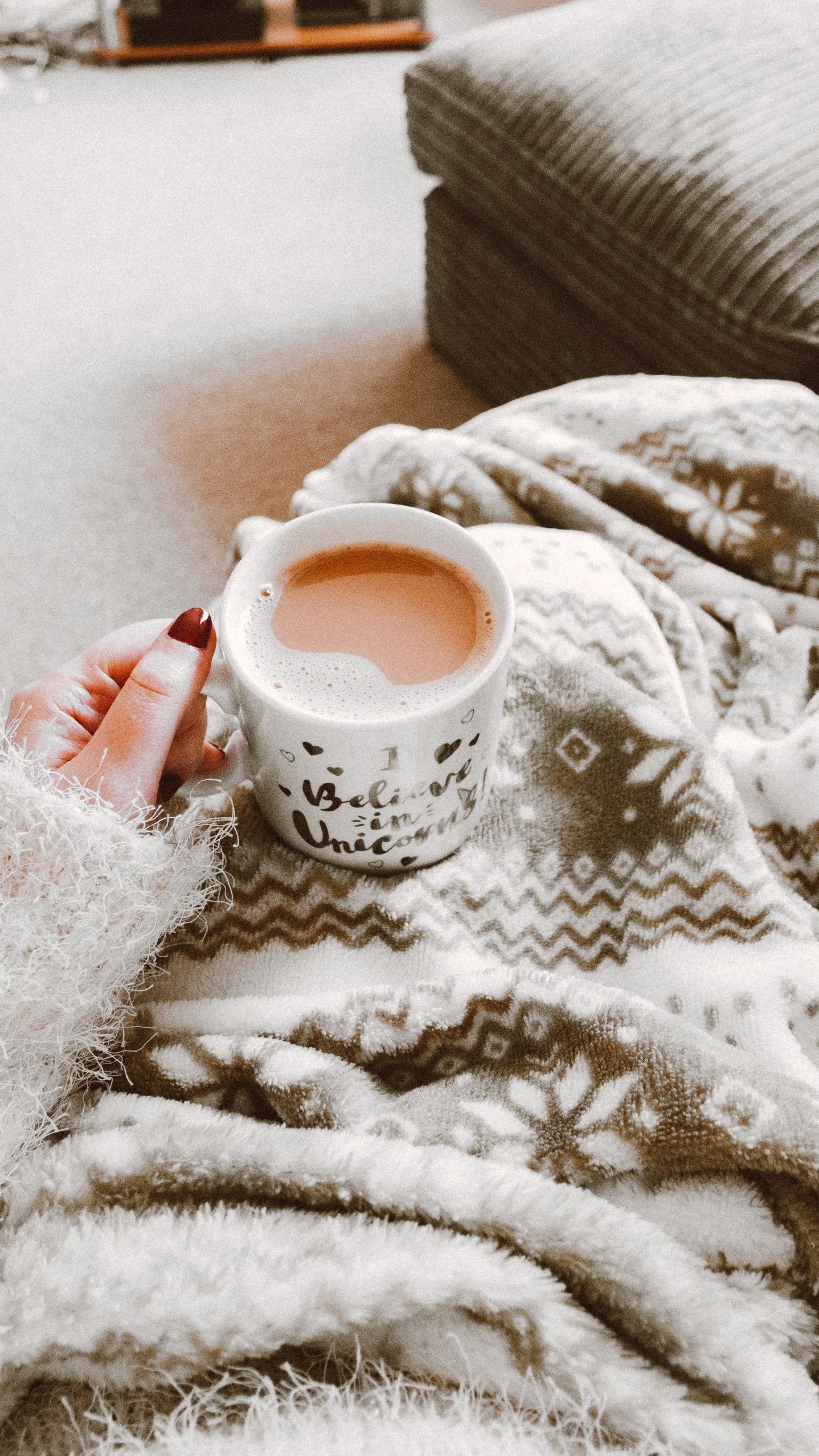 Blanket and coffee A person is holding a cup of coffee on a blanket.