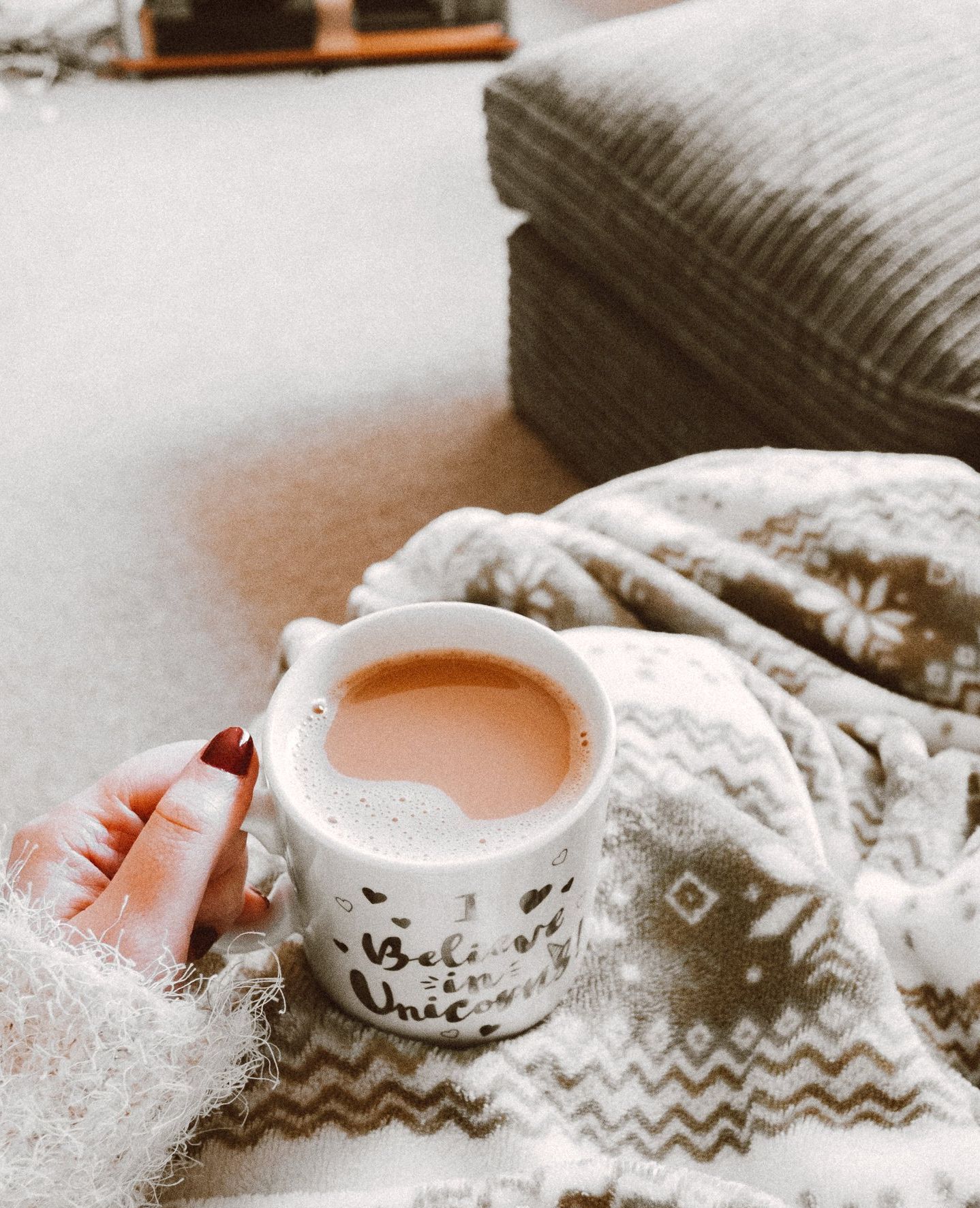Blanket and coffee A person is holding a cup of coffee on a blanket.