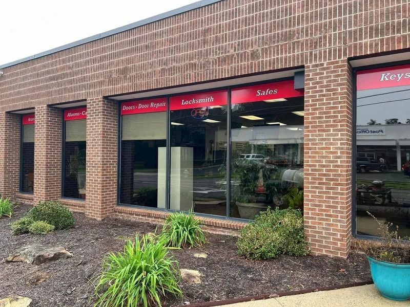 A brick building with large windows; store signs read 