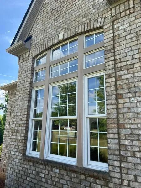 Large multi-paned window set in brick wall of a building.