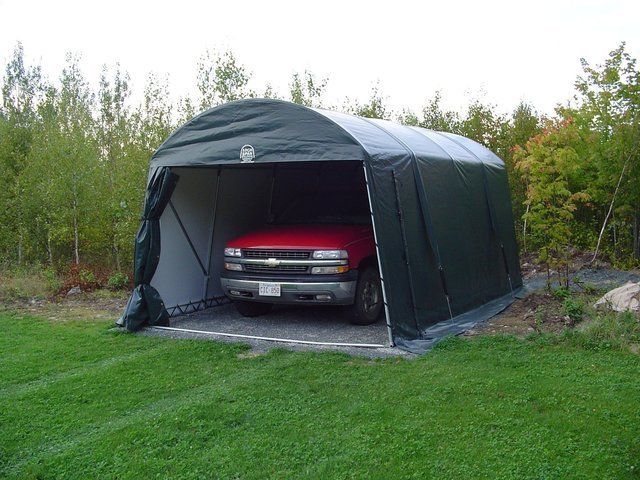 A red truck is parked in a green garage.