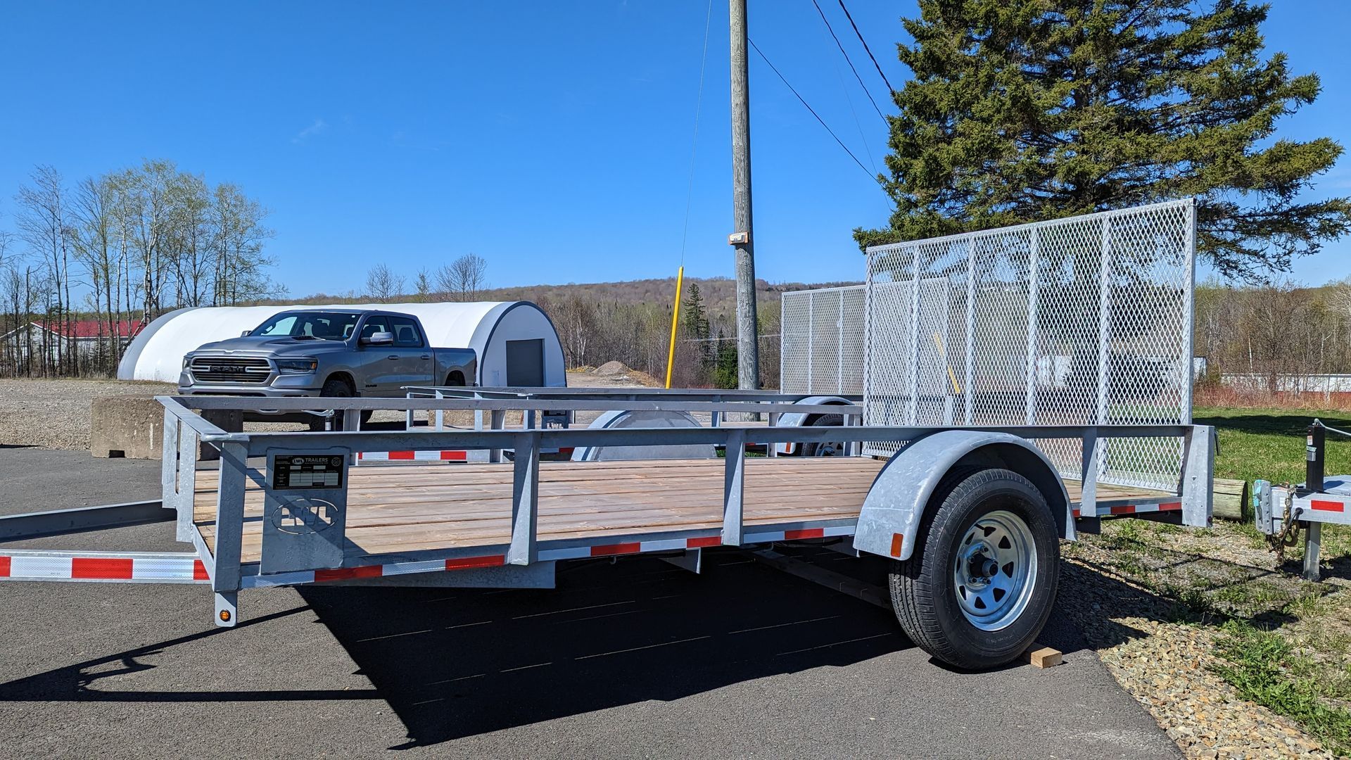 A small trailer is parked on the side of the road.