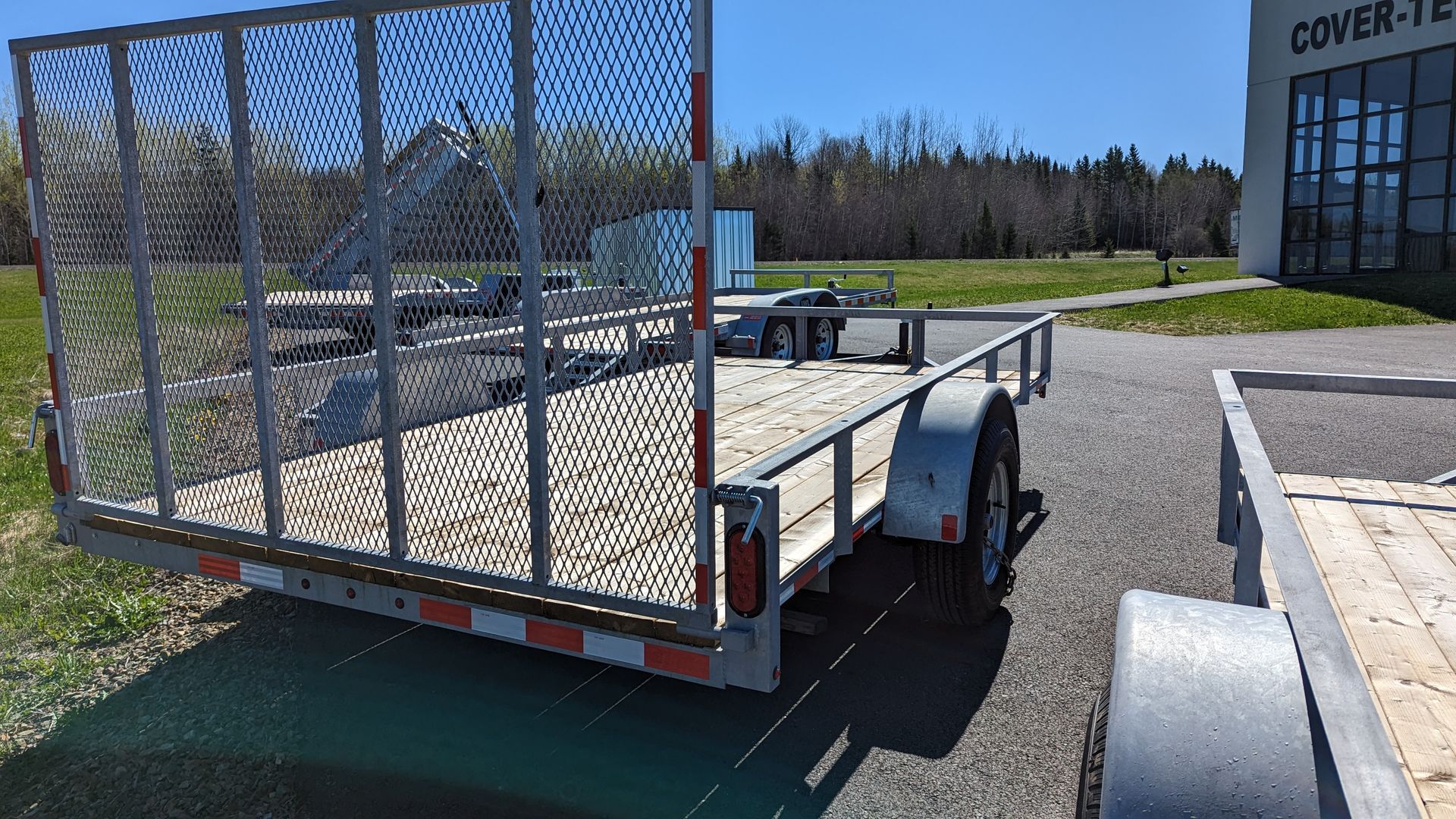 A trailer is parked in a parking lot in front of a building.