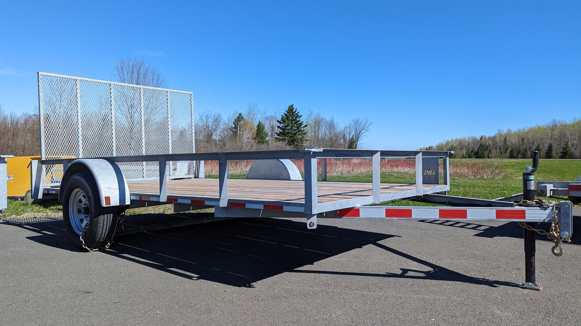 A small trailer is parked on the side of the road.