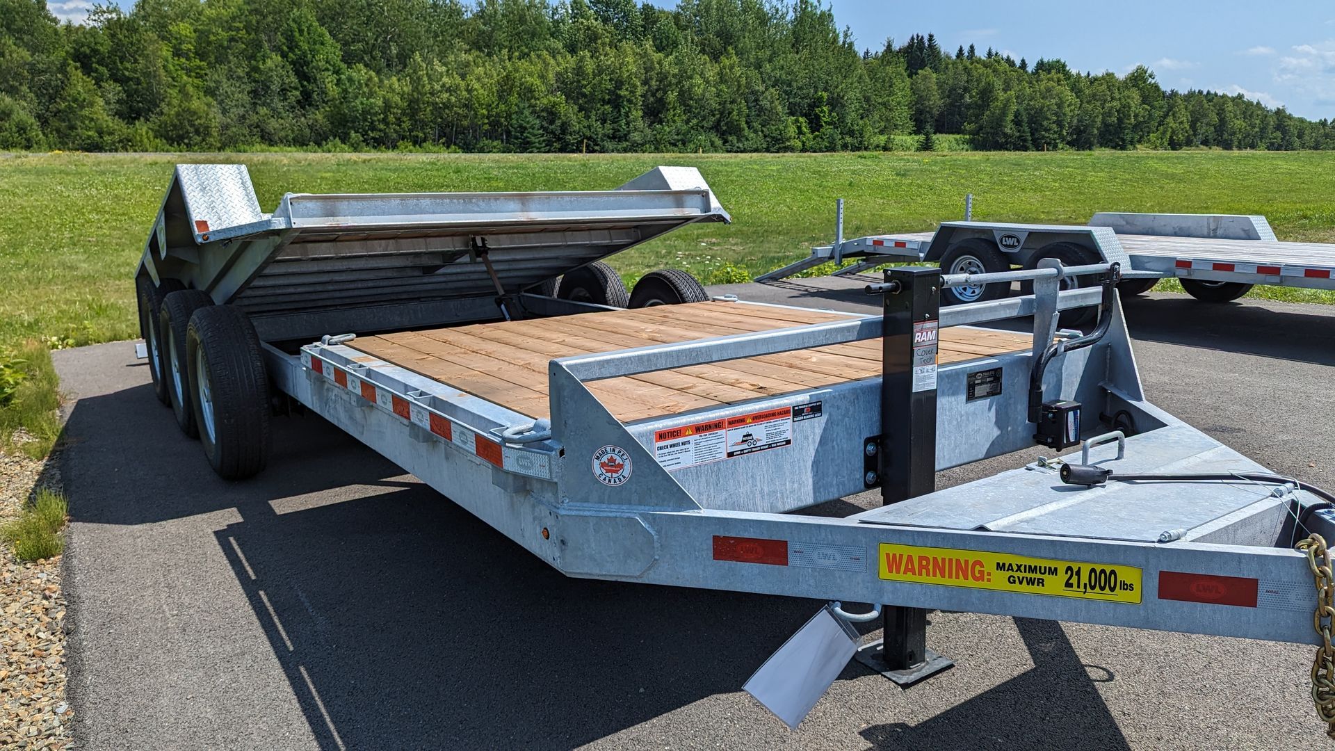 A trailer is parked on the side of the road next to a field.