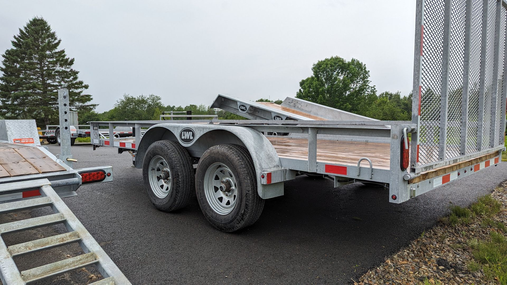 A trailer is parked on the side of the road next to a ramp.