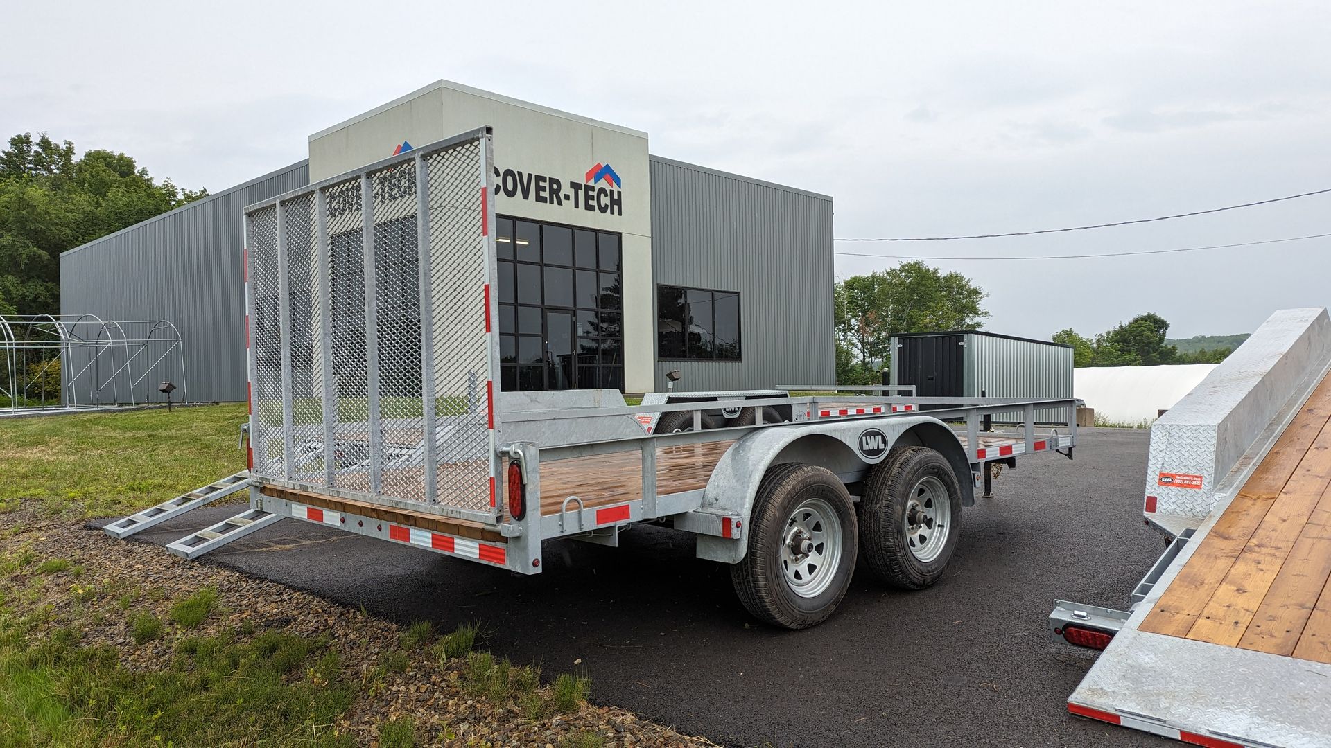 A trailer is parked in front of a building in a parking lot.
