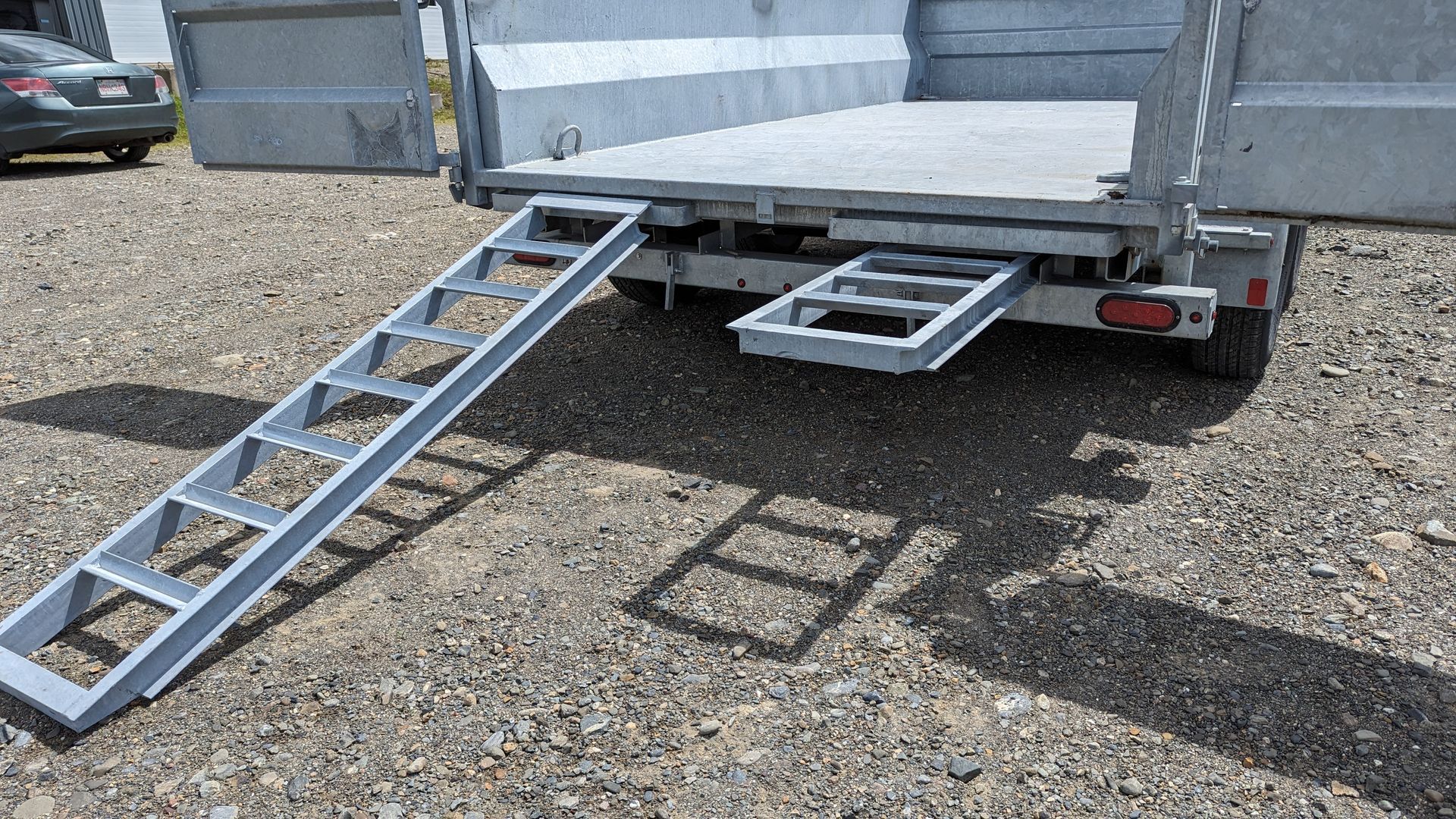 A trailer with a ramp attached to the back of it.