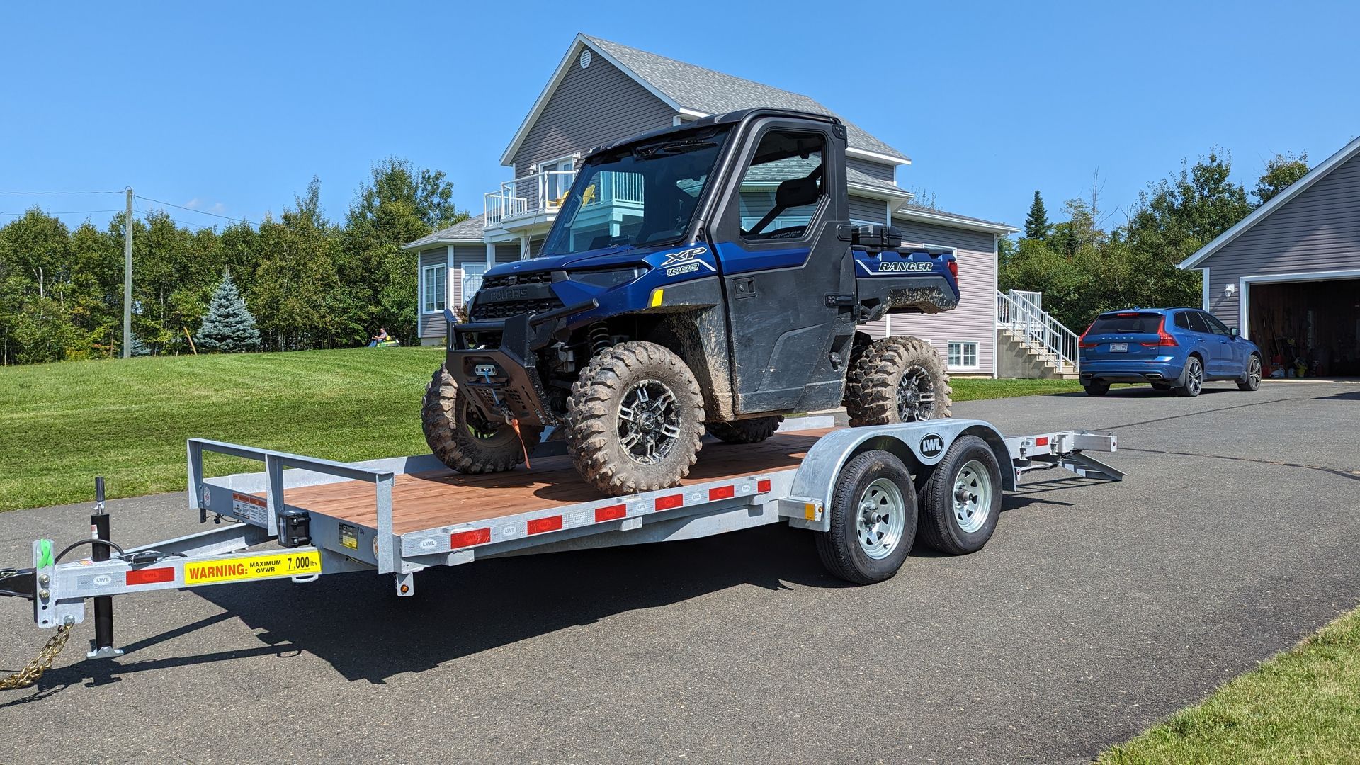 A blue atv is sitting on top of a trailer.