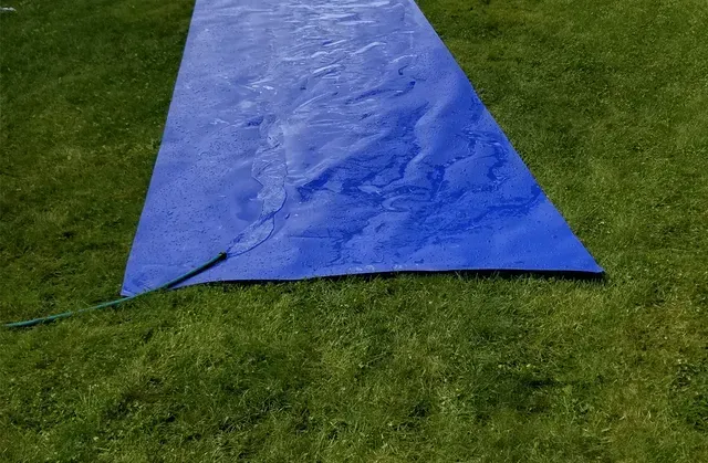 Blue slip-n-slide on green grass. Cover-Tech Slippy Slope Slip and Slides,