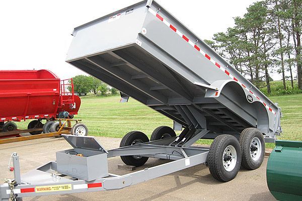 A dump trailer is parked on the side of the road