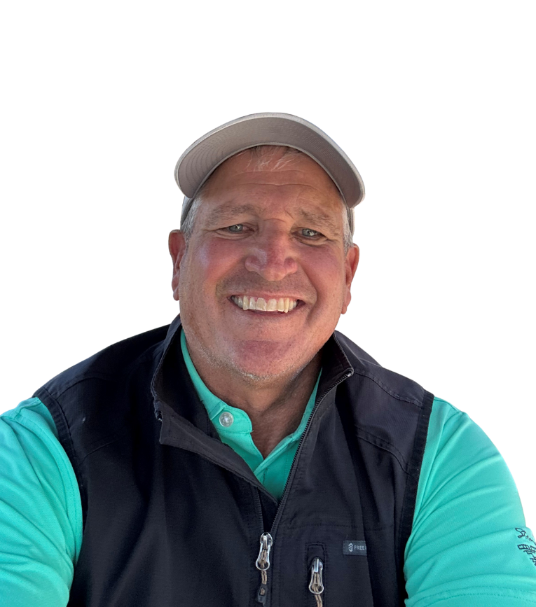 Man wearing a cap, smiling, in a turquoise shirt and dark vest, set against a white background.