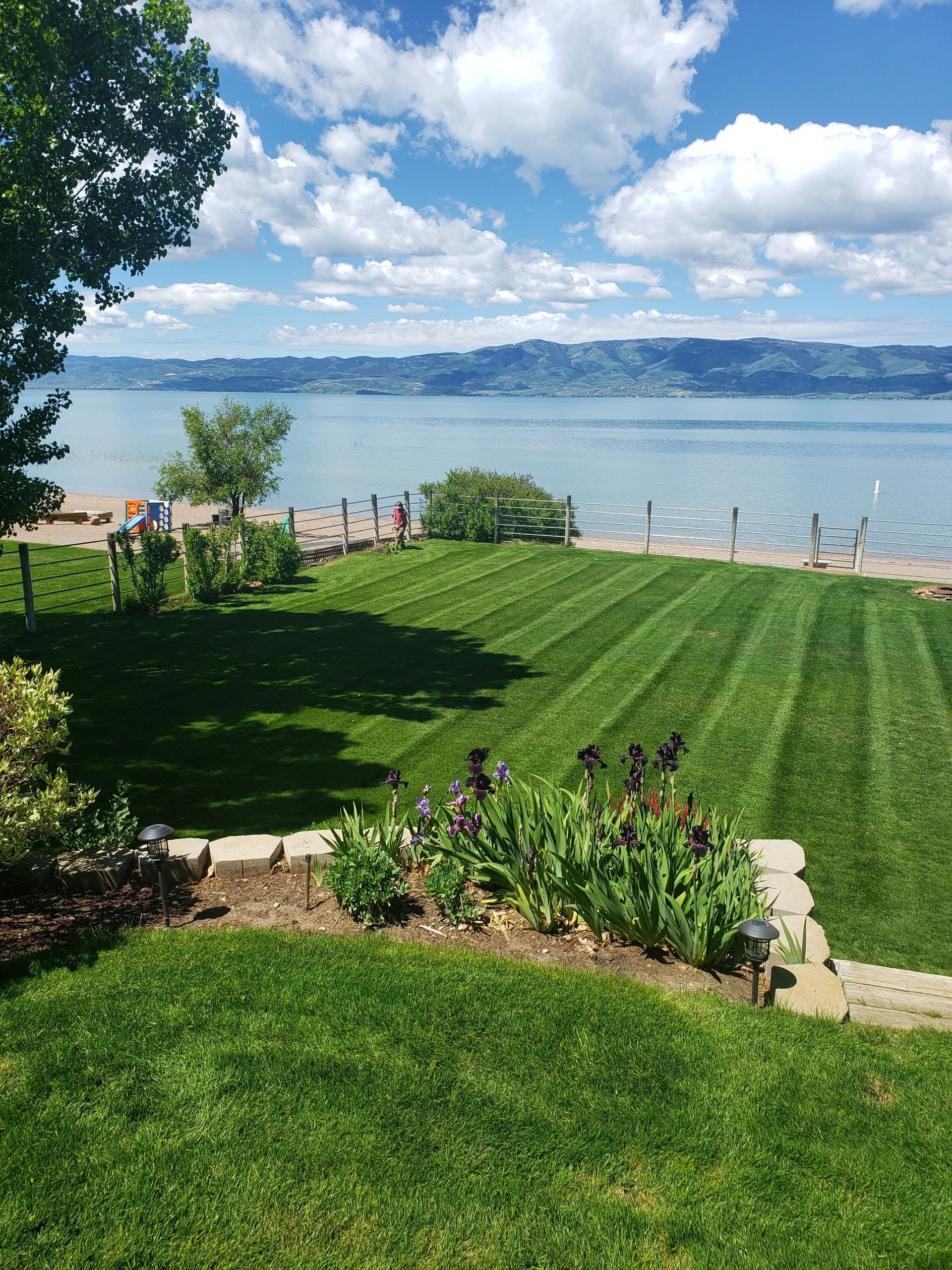 A Lush Green Lawn with A View of A Lake on A Sunny Day.