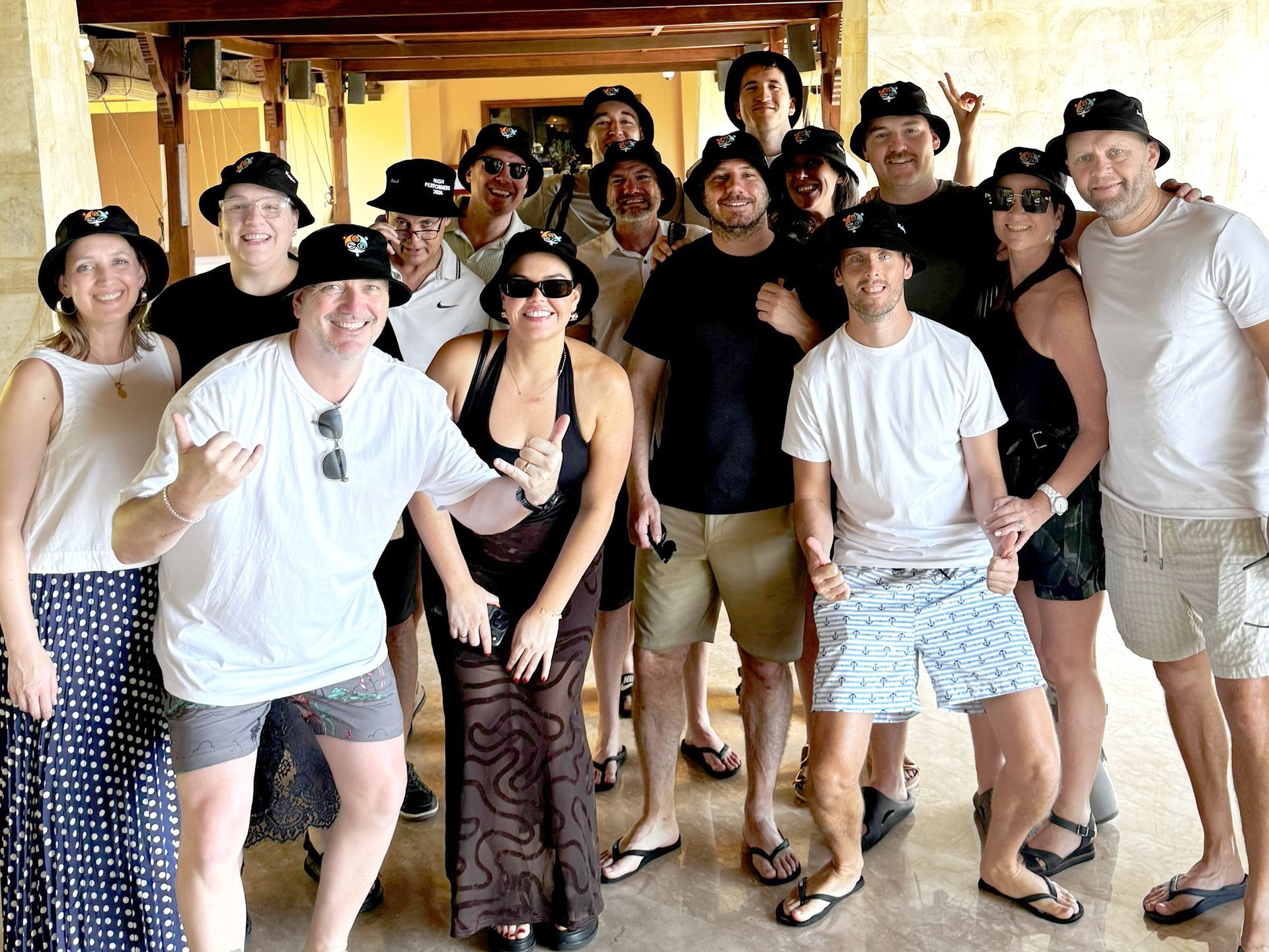 Group of people posing indoors, smiling and dancing in casual clothes at a lively gathering