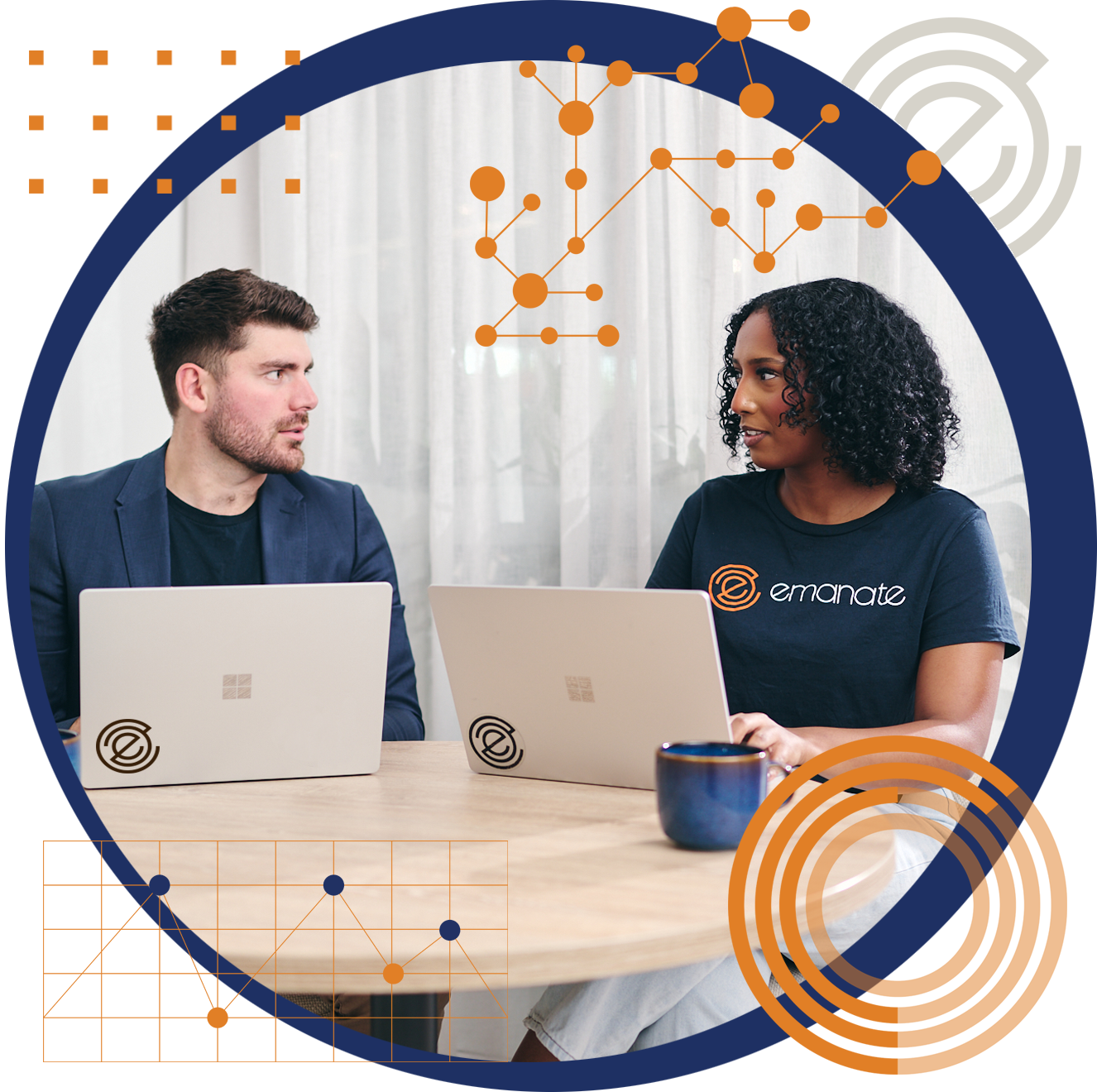 A man and a woman are sitting at a table with laptops.