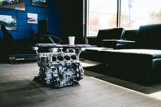 Robot coffee table in a modern lounge with blue walls and black sofas