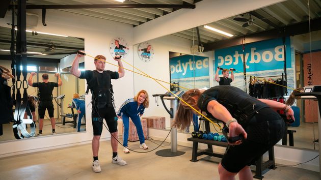 Een groep mensen doet oefeningen in een sportschool.