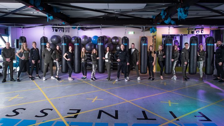 Een groep mensen poseert voor een foto in een sportschool.