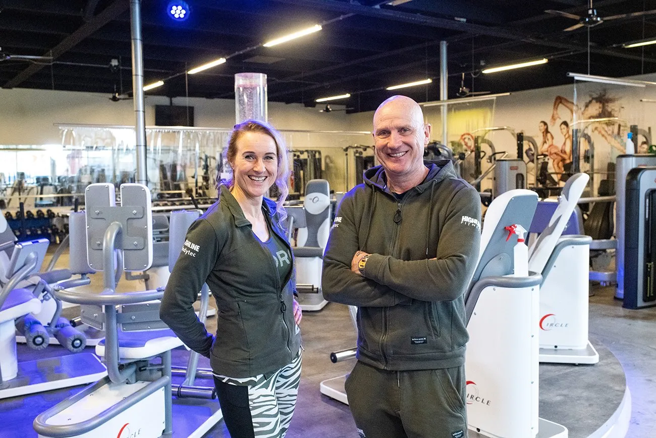 Een man en een vrouw staan ​​naast elkaar in een sportschool.