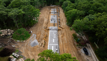 An aerial view of a dirt road in the middle of a forest.