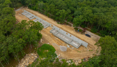 An aerial view of a construction site in the middle of a forest.