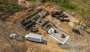 An aerial view of a house under construction in the woods.