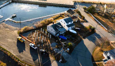 An aerial view of a house next to a body of water