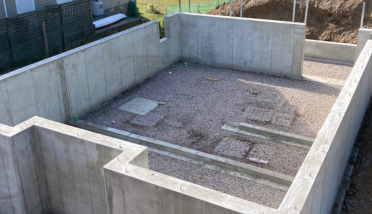 A concrete basement under construction with gravel in it.