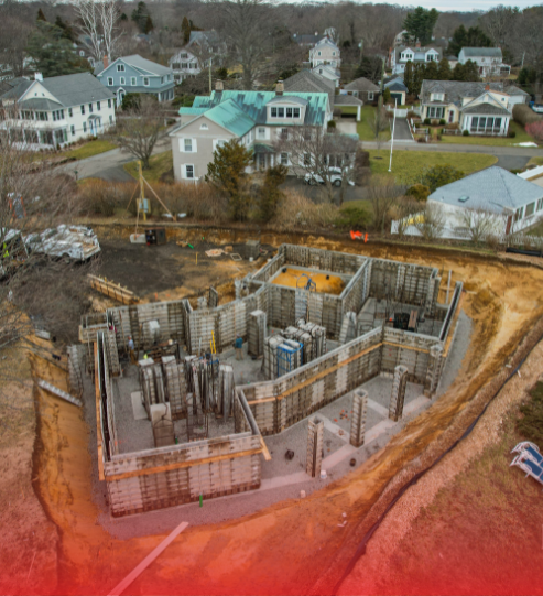An aerial view of a construction site with houses in the background