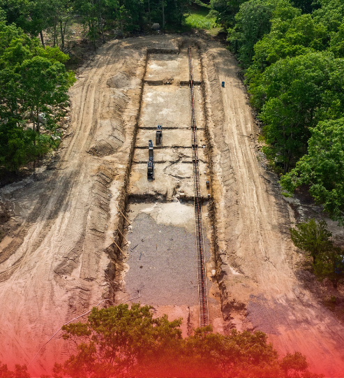 An aerial view of a dirt road surrounded by trees.