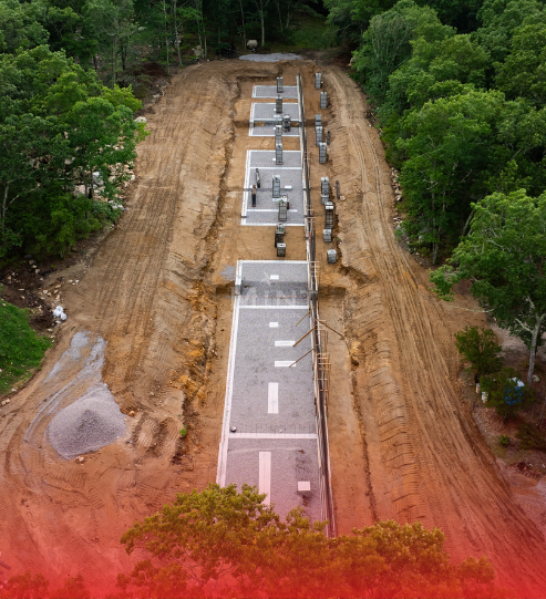 An aerial view of a dirt road in the middle of a forest.