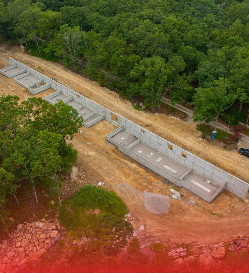 An aerial view of a road under construction in the middle of a forest.