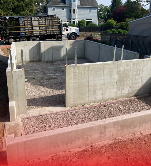 A truck is parked in front of a concrete wall.