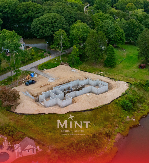 An aerial view of a house under construction in the middle of a forest.
