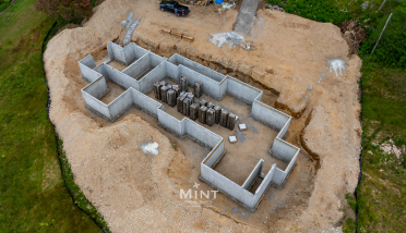 An aerial view of a house under construction in the middle of a dirt field.