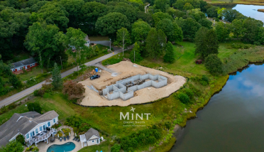 An aerial view of a house under construction next to a lake.