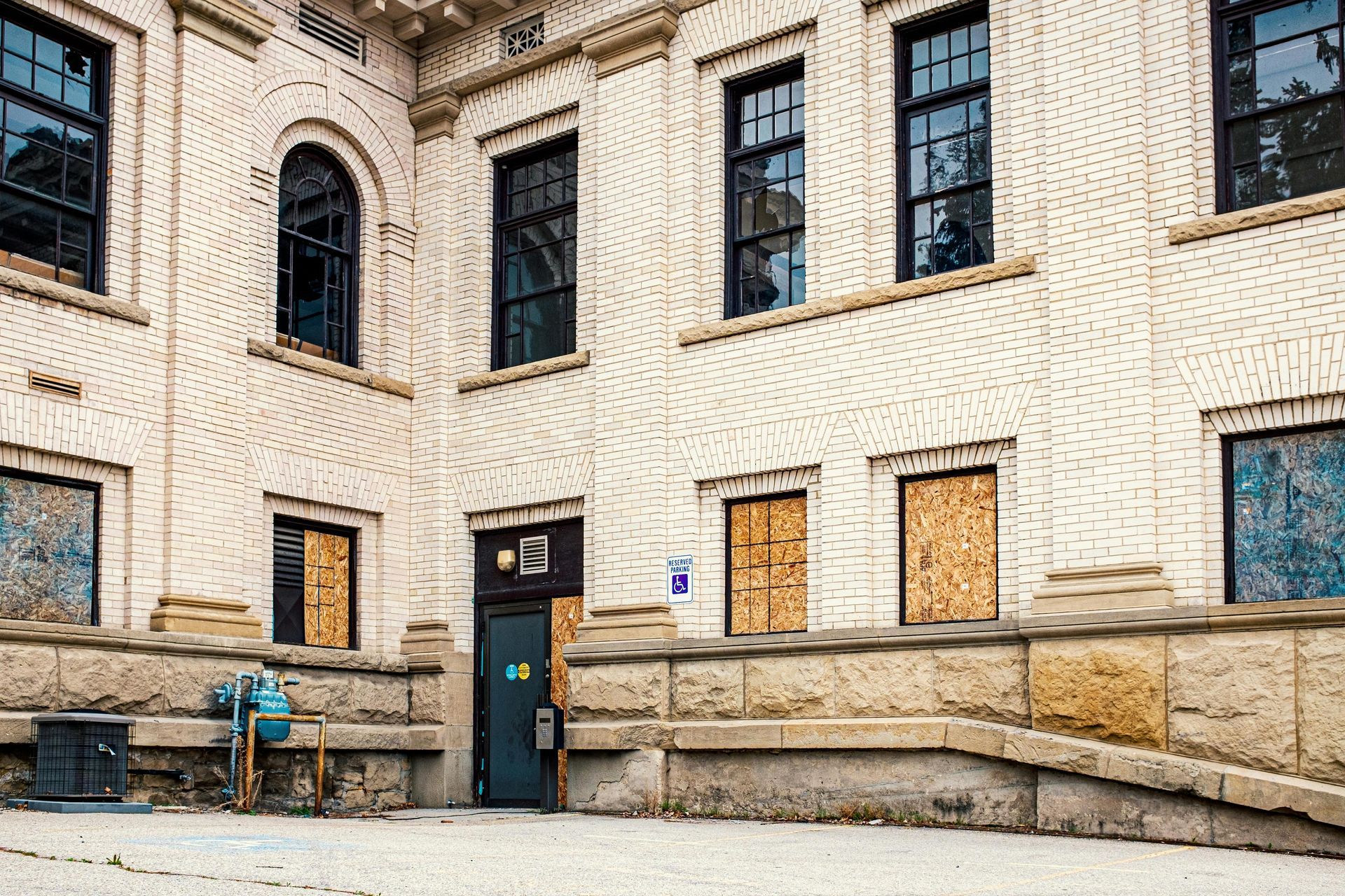 Stone building facade with arched windows and a central blue door