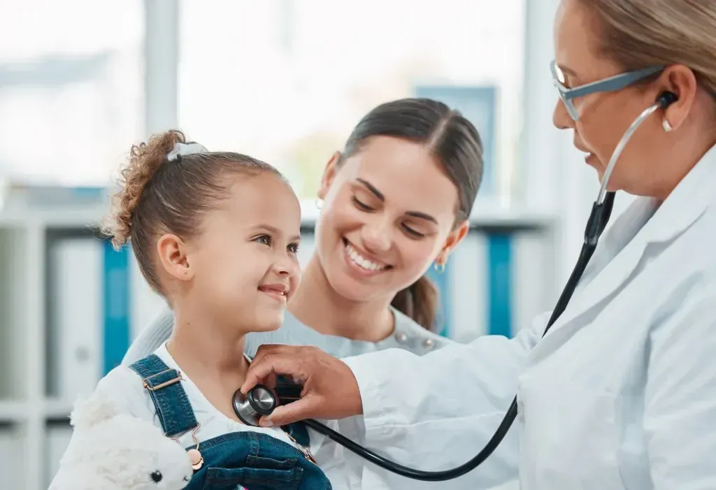 Doctor listening to a little girl's heart with a stethoscope.